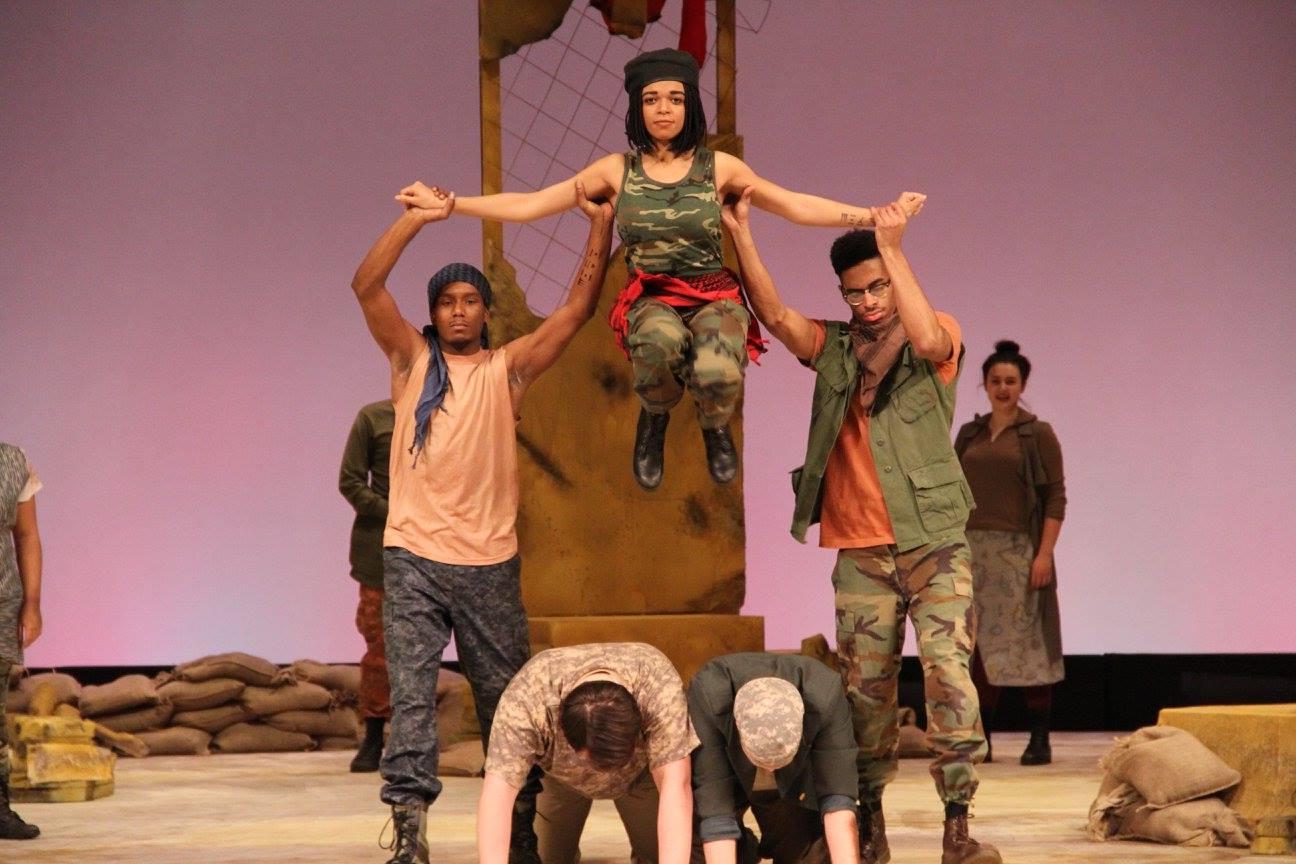 Two male theatre students holding up a female theatre student